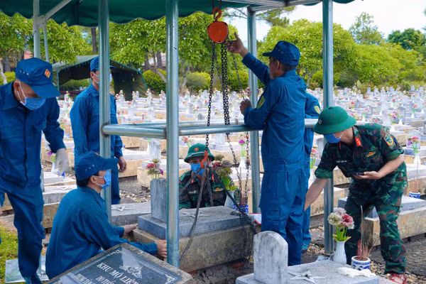 Lực lượng chức năng triển khai lấy mẫu ở phần mộ liệt sĩ. Ảnh: Xuân Diện