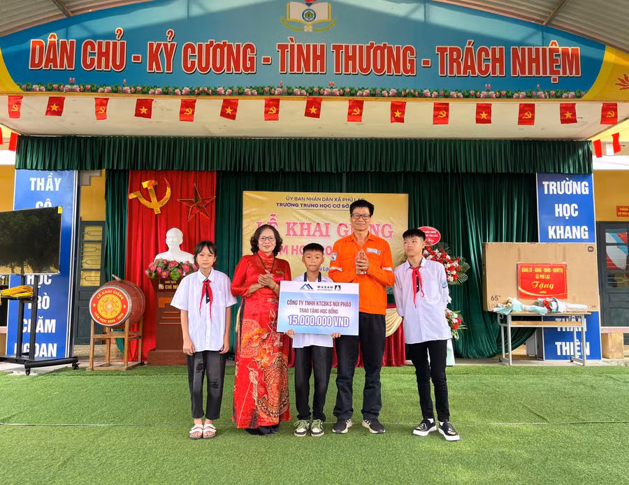 Đại diện Công ty TNHH Khai thác Chế biến Khoáng sản Núi Pháo trao quà cho các em học sinh. 