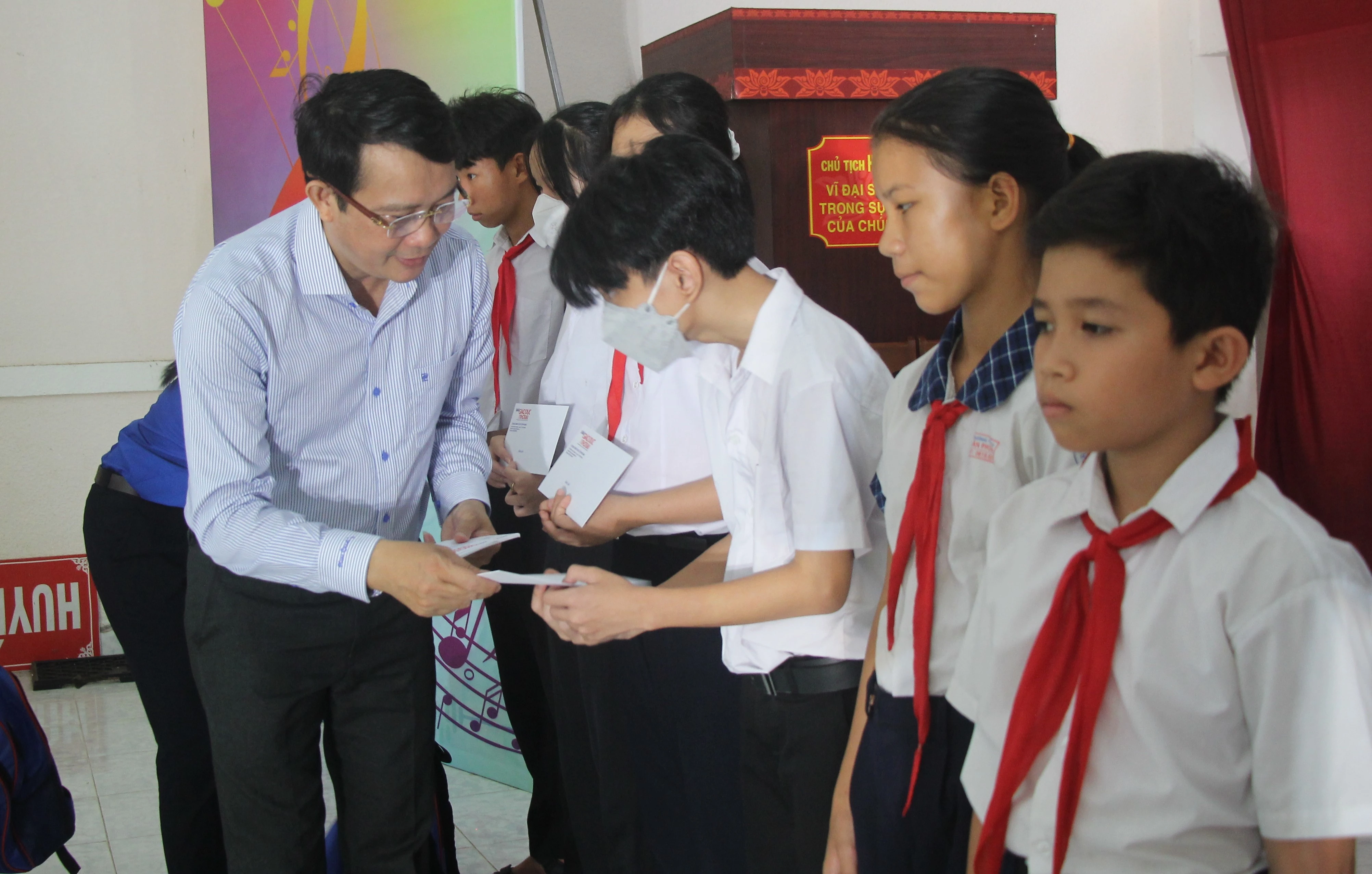 Ông Lê Thắng Lợi, Phó Giám đốc Trung tâm Phát triển GD&amp;ĐT phía Nam trao học bổng cho học sinh.