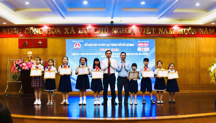 Hoàng Đức Minh, Vụ trưởng Vụ học sinh Sinh viên (Bộ GD&ĐT) và Trần Nguyên Hãn, Giám đốc Công ty TNHH Tư vấn & Đào tạo Đại Dương trao giải cho các em học sinh.