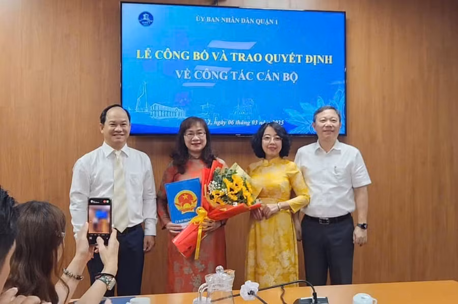 Bí thư Quận uỷ Quận 1 Dương Anh Đức (ngoài cùng bên phải) và lãnh đạo UBND quận 1 trao quyết định cho bà Lê Thị Thanh Giang.