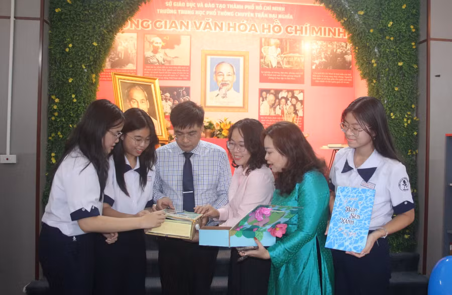Lãnh đạo Ban Tuyên giáo Quận uỷ Quận 1, Trường THPT chuyên Trần Đại Nghĩa cùng cô Trần Kim Duyên và học trò xem các tác phẩm về Bác Hồ. 