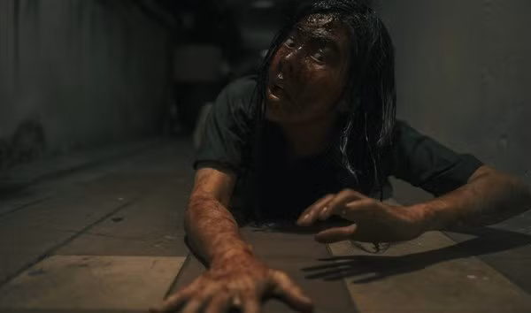 Diễn viên Vân Trang trườn bò la hét, kèm khuôn mặt đầy máu trong một cảnh phim.