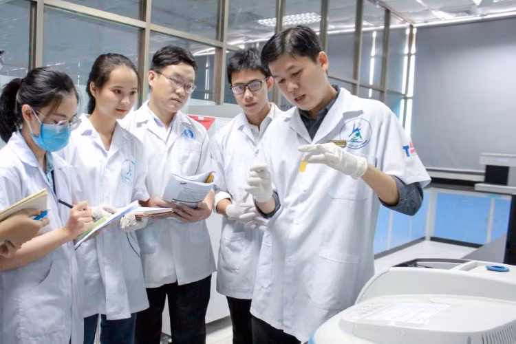 TS Nguyễn Hoàng Chinh (bên phải) hướng dẫn SV làm nghiên cứu. Ảnh: NVCC