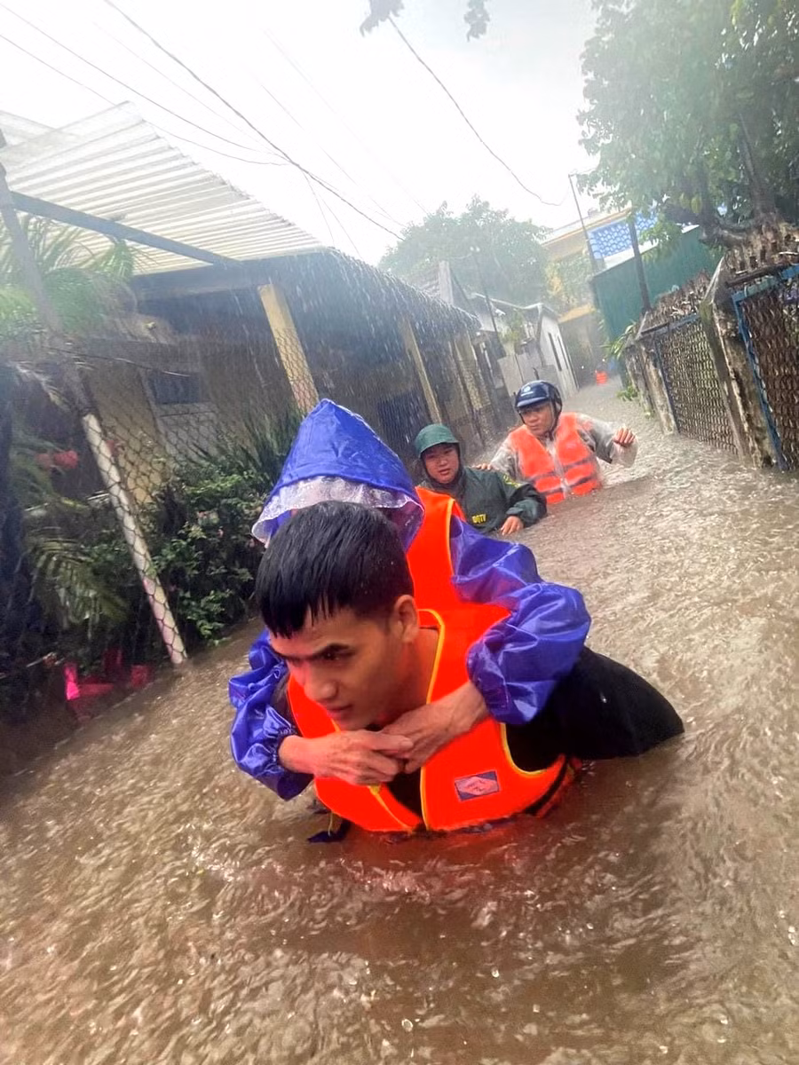 Công an đưa người già, thai phụ di tản khỏi nơi ngập lũ.