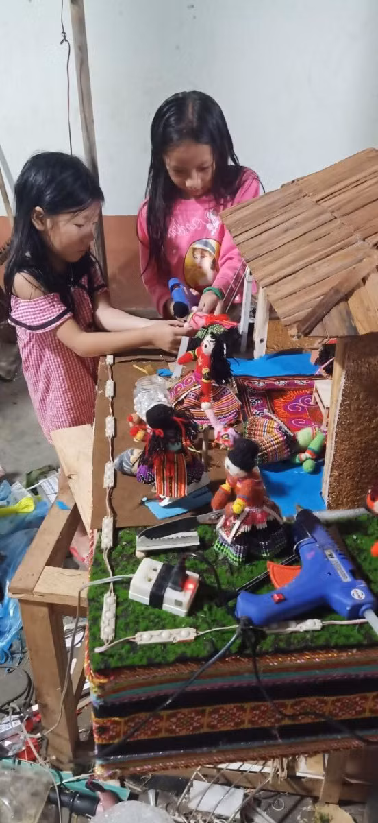 2 chị em Thào Thị Kim Ngân, Thào Thị Kim Phương lắp ráp mô hình.