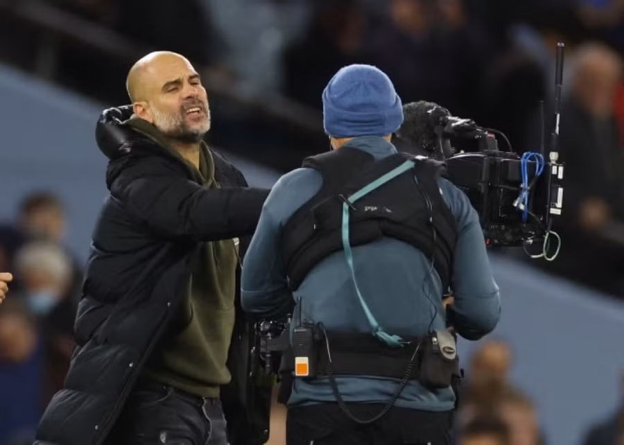 Guardiola đẩy máy quay của phóng viên đi khi tiếng còi mãn cuộc vang lên.