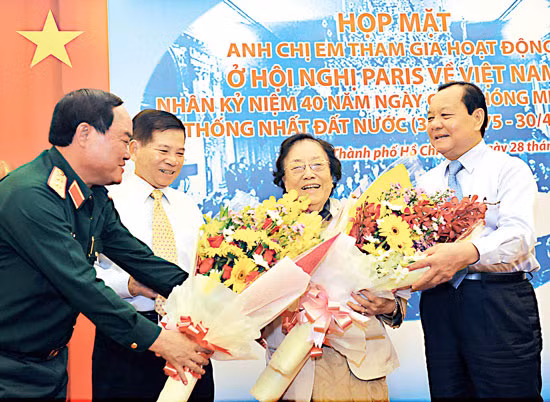 Nguyên Phó Chủ tịch nước Nguyễn Thị Bình nhận hoa chúc mừng khi tham gia họp mặt anh chị em từng dự Hội nghị Paris về Việt Nam