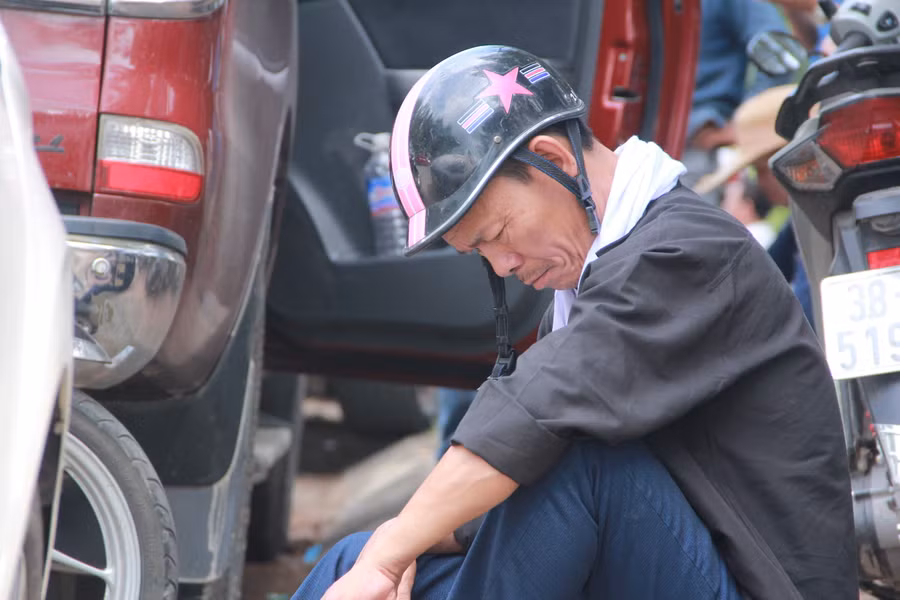 Ông Võ Tá Dũng ngồi chờ con ở điểm thi Trường THPT Thành Sen.