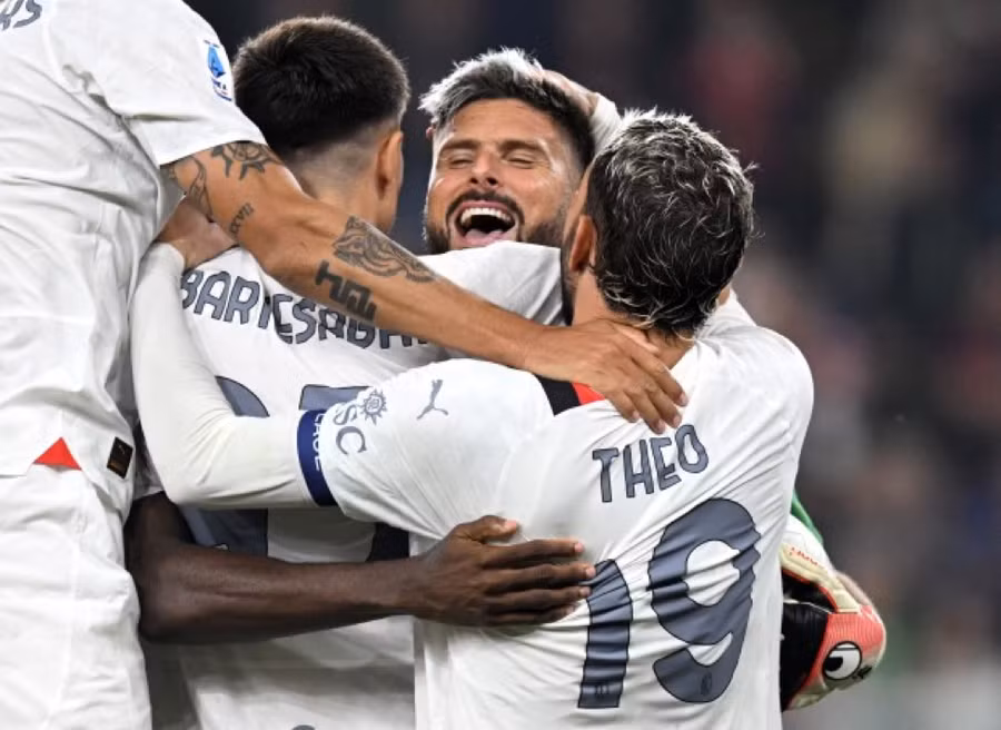 Cầu thủ AC Milan ôm ‘thủ thành’ Giroud mừng AC Milan chiếm ngôi đỉnh bảng Serie A.