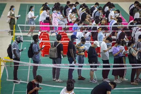 Sinh viên Trường ĐH Y Hải Nam, Trung Quốc xếp hàng chờ tiêm vắc-xin.