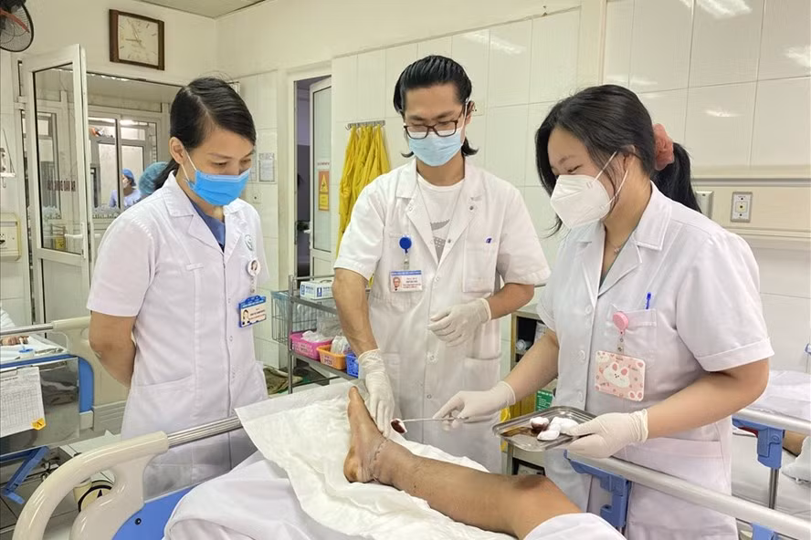 Các bác sĩ kiểm tra chân bệnh nhân sau ca phẫu thuật. Ảnh: BVCC.