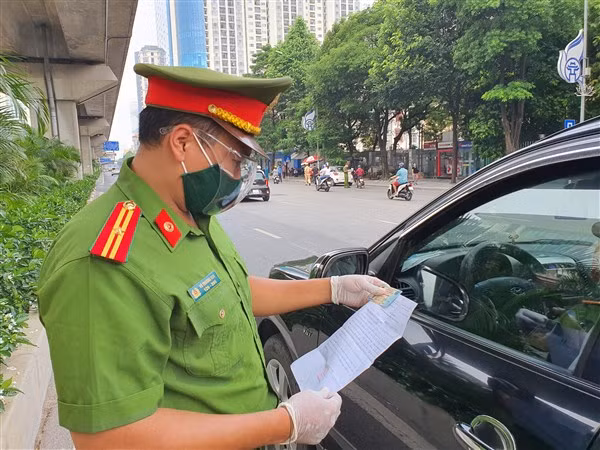Trong thời gian giãn cách xã hội tại TP Hà Nội thì người dân tham gia giao thông phải xuất trình giấy đi đường. 