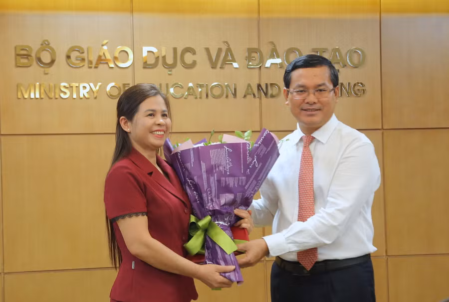 Thứ trưởng Nguyễn Văn Phúc trao quyết định và tặng hoa chúc mừng tân Phó Cục trưởng Đặng Thị Oanh. Ảnh: Việt Hà