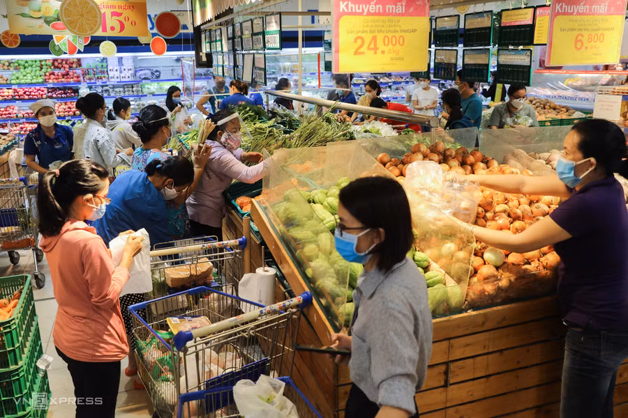 Người dân phải cho xếp hàng thành ba lớp, khi vào được bên trong tiếp tục ngồi chờ ở hành lang rồi đợi ở cạnh các quầy thu ngân để được vào trong mua sắm. Mỗi lượt vào không quá 80 người. Nguồn: VNE.