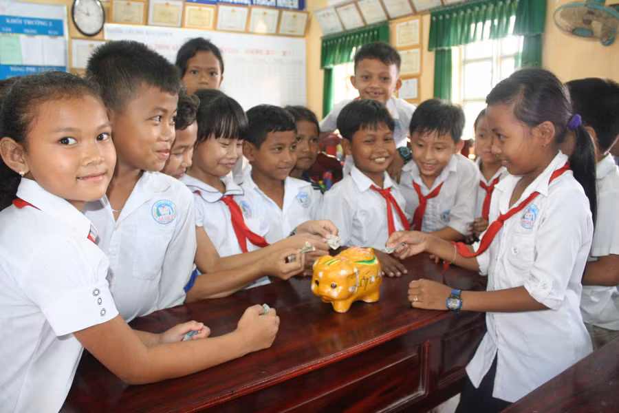 Học sinh Trường Tiểu học Hàm Giang B (Trà Cú) nuôi heo đất để hỗ trợ bạn học hoàn cảnh khó khăn. Ảnh: Q. Ngữ