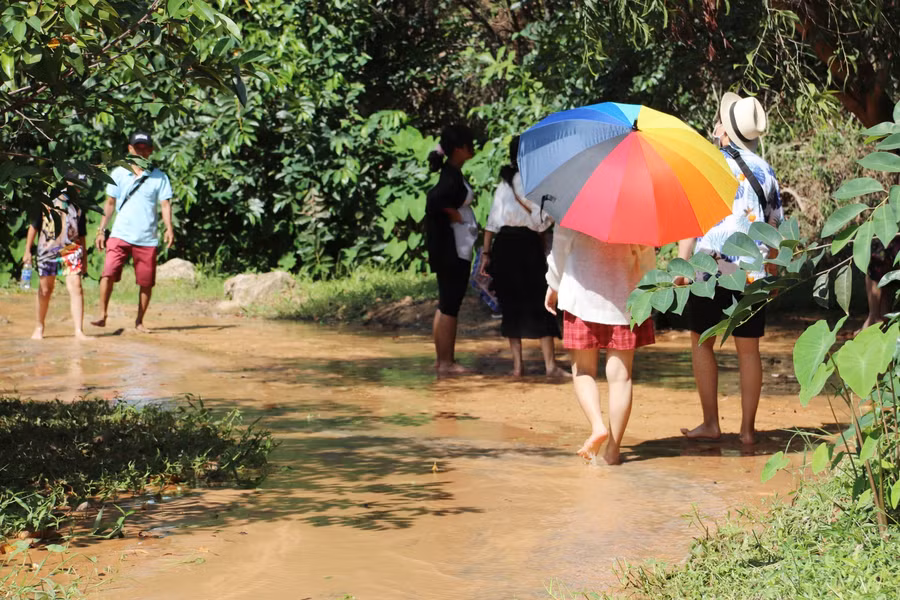 Lối đi dễ nhất để khám phá Suối Hồng nằm trên đường Huỳnh Thúc Kháng, phường Mũi Né, TP Phan Thiết, tỉnh Bình Thuận. Điểm dừng chân ở lối vào suối là chân cầu nằm ngay ven đường. Tại đây, du khách có thể gửi xe ở những quán ăn, quán cà phê kiêm luôn dịch vụ giữ xe, giữ đồ cho du khách tham quan lội suối ngắm cảnh.
