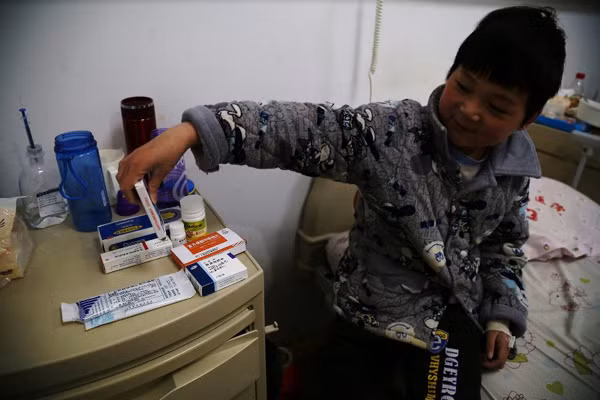 Chen Minghao, the 9-year-old with leukemia, says he is not afraid of taking the medicines on the desk at the hospital