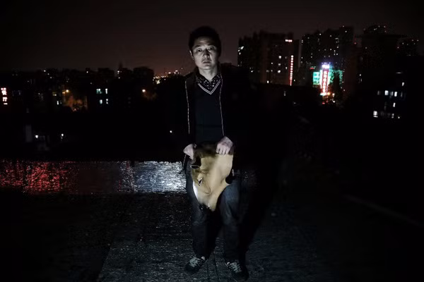 Chen Yuntao takes a photo with his horse head mask late at night in Hefei, capital city of Anhui province on Monday. He doesn