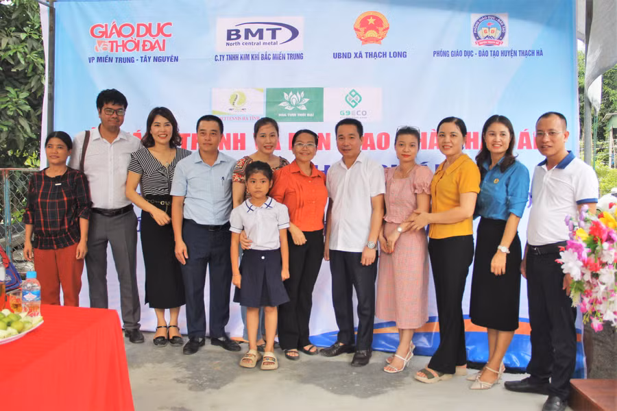 Đại diện nhà tài trợ, chính quyền địa phương, trường học chụp ảnh cùng gia đình 3 mẹ con chị Nga.