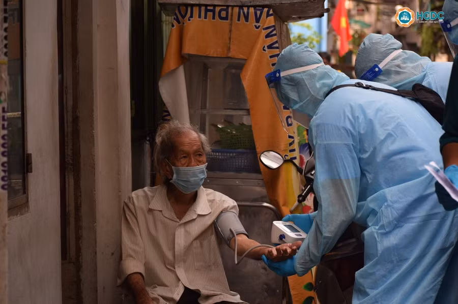 Nhân viên y tế tư vấn và đo huyết áp, nồng độ oxy trong máu trước khi tiêm vắc xin cho người dân. Nguồn: HCDC TP Hồ Chí Minh.