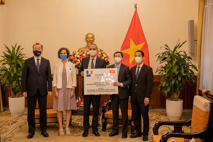 Thứ trưởng Bộ Ngoại giao Tô Anh Dũng và Thứ trưởng Bộ Y tế Trần Văn Thuấn tiếp nhận tượng trưng 812.060 liều vắc xin AstraZeneca của Italia ủng hộ thông qua Cơ chế COVAX hôm 14/9. Ảnh: UNICEF tại Việt Nam.