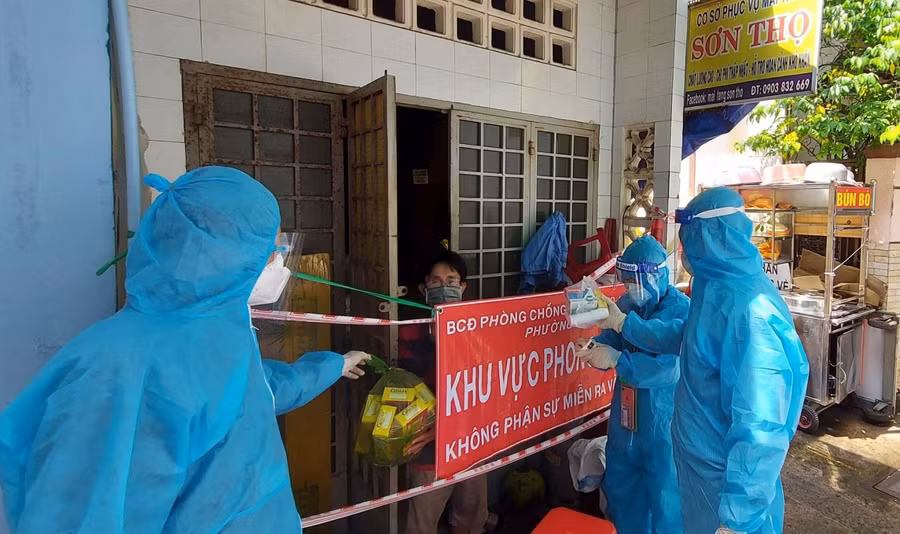 Cán bộ quận Tân Bình đang trao những túi thuốc an sinh cho các F0 điều trị tại nhà. Ảnh: Hoàng Tuyết.
