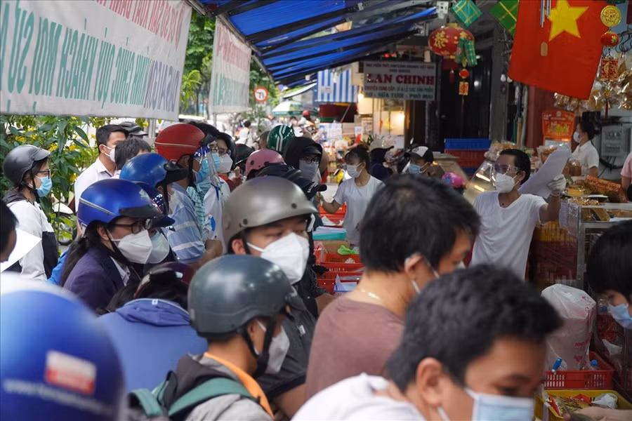 Ngoài các shipper đến mua bánh thì cũng có khá đông những người dân khác đến mua, chen chúc nhau không đảm bảo các an toàn trong công tác phòng chống dịch Covid-19. Ảnh: LĐO.