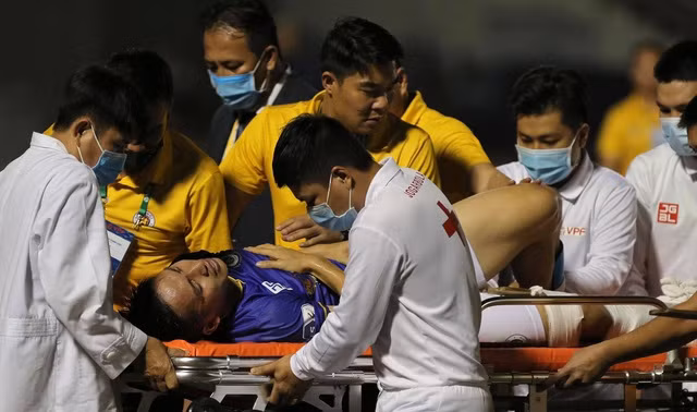 Hùng Dũng được đưa lên xe cấp cứu sau cú vào bóng của Hoàng Thịnh.