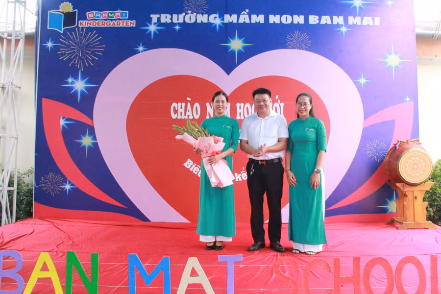 Đại diện hội phụ huynh tặng hoa chúc mừng nhà trường. (Ảnh: Vũ Long)
