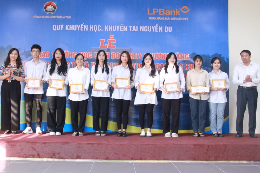 Lãnh đạo Ban Dân vận Tỉnh ủy và Ngân hàng Nhà nước tỉnh trao thưởng cho các em học sinh.