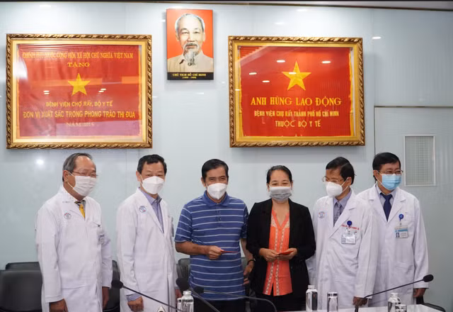 TS.BS Nguyễn Tri Thức lì xì chúc mừng hai vợ chồng bệnh nhân B. Ảnh: BV.
