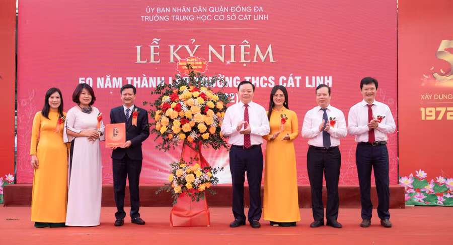 Lãnh đạo Quận ủy, HĐND, UBND, UB MTTQ quận Đống Đa tặng hoa thầy và trò nhà trường.