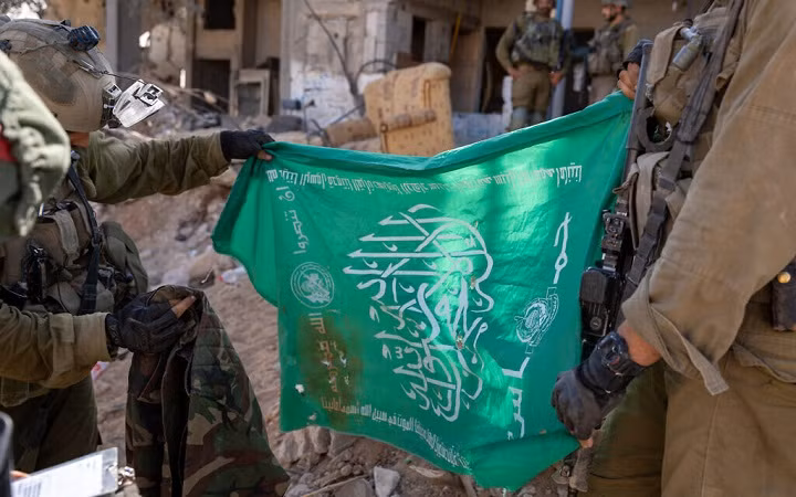 Cờ Hamas và áo khoác ngụy trang được lôi ra từ một đường hầm ở phía bắc Dải Gaza, ngày 7/11/2023 Cờ Hamas và áo khoác ngụy trang được lôi ra từ một đường hầm ở phía bắc Dải Gaza, ngày 7/11/2023