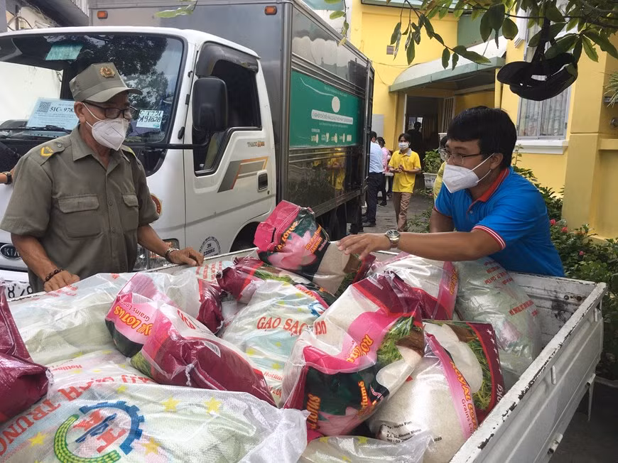 Tình người đã và đang lan tỏa trên từng tuyến đường, ngõ hẻm, khu vực phong tỏa, cách ly ở TP Hồ Chí Minh. Trong ảnh: Tiếp nhận và vận chuyển, hàng hóa, quà tặng cho người dân ở 14 phường, quận 3. Nguồn: TTXVN.