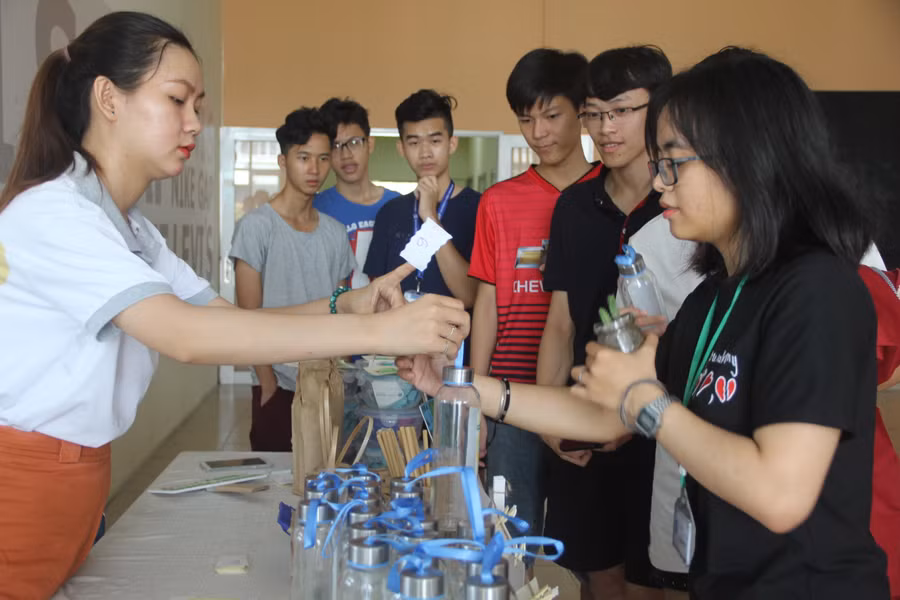 Sinh viên sau khi tham gia buổi triển lãm nhận các món quà như bình thủy tinh, ống hút tre, túi vải lúc ra về.