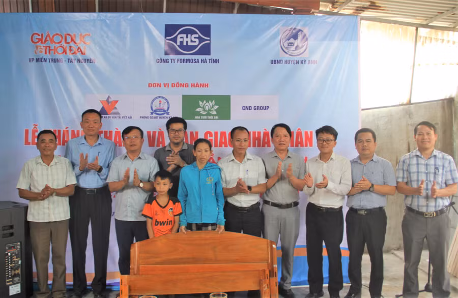 Nhà tài trợ cùng chính quyền địa phương tặng quà cho mẹ con chị Thanh tại Lễ bàn giao nhà nhân ái. (Ảnh: T.H).
