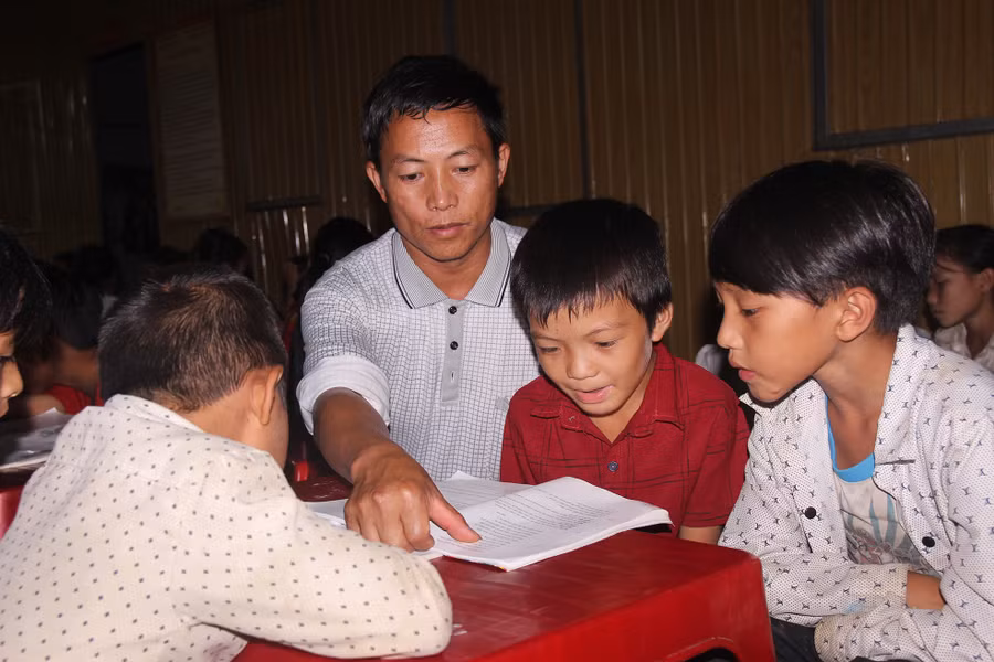 Học sinh được thầy cô hướng dẫn học phụ đạo kiến thức buổi tối