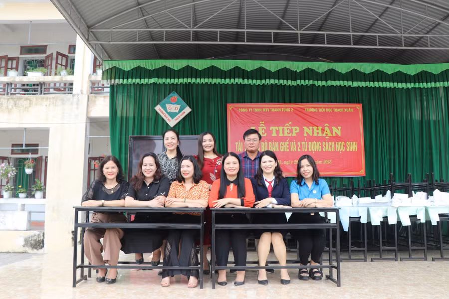 Giáo viên rất vui mừng khi đón nhận món quà mà Công ty Thanh Tùng 2 trao tặng học sinh của Trường Tiểu học Thạch Xuân. (Ảnh: Vũ Long).