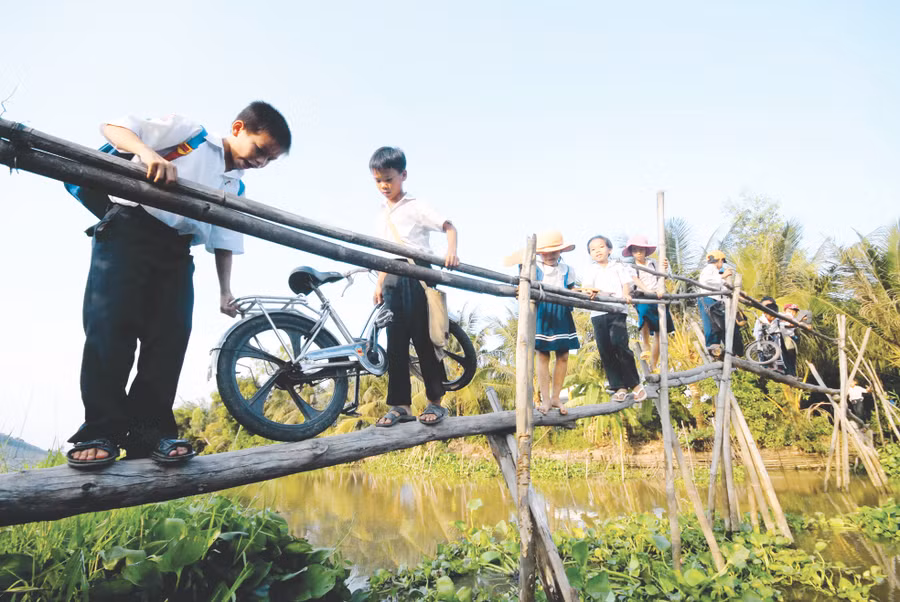 Học sinh ở huyện Phụng Hiệp (Hậu Giang) vượt cầu khỉ đến trường. Ảnh: H. Vũ