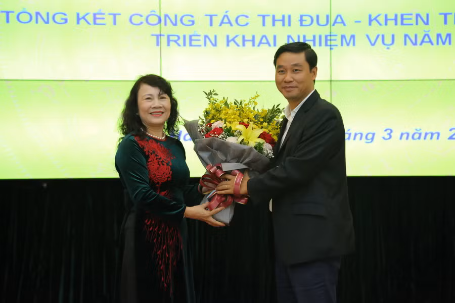 Thứ trưởng Nguyễn Thị Nghĩa tặng hoa chúc mừng ĐHQG Hà Nội, đơn vị được giao Trưởng khối thi đua năm 2019. Ảnh Việt Hà