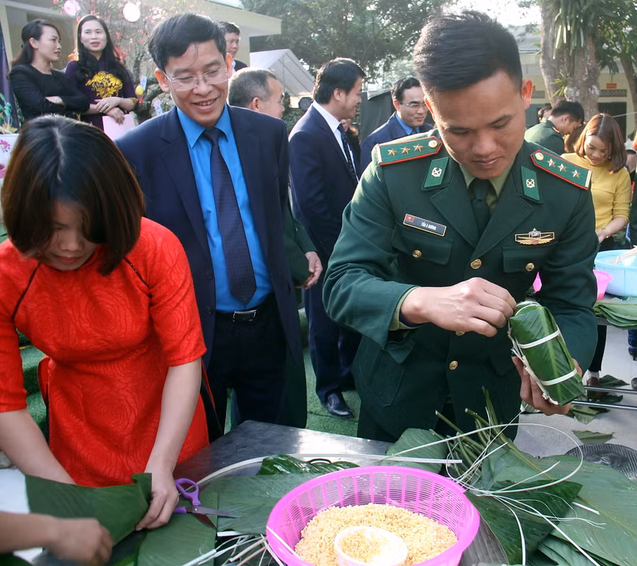 Chủ tịch Công đoàn Giáo dục Việt Nam - Ông Vũ Minh Đức đang xem Thượng úy Tần A Dương hoàn thiện chiếc bánh của đội mình