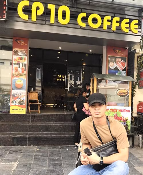 Công Phượng chụp ảnh trước quán cà phê của bản thân.