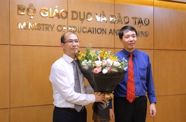 Ông Phạm Quang Hưng - Cục trưởng Cục Hợp tác quốc tế tặng hoa chúc mừng tân Phó Cục trưởng Nguyễn Tiến Dũng. Ảnh: Việt Hà