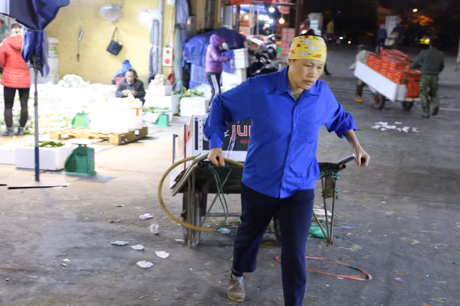 Những người phụ nữ chở hàng thuê ở chợ hoa quả Long Biên dù trời rét thế nhưng họ chỉ mặc chiếc áo mỏng vì khi làm vất vả thường có mồ hôi. Họ cần mẫn làm xuyên đêm, ai cũng cố hết sức để chở được nhiều chuyến, mong có thêm tiền chi tiêu cho Tết đang đến gần.