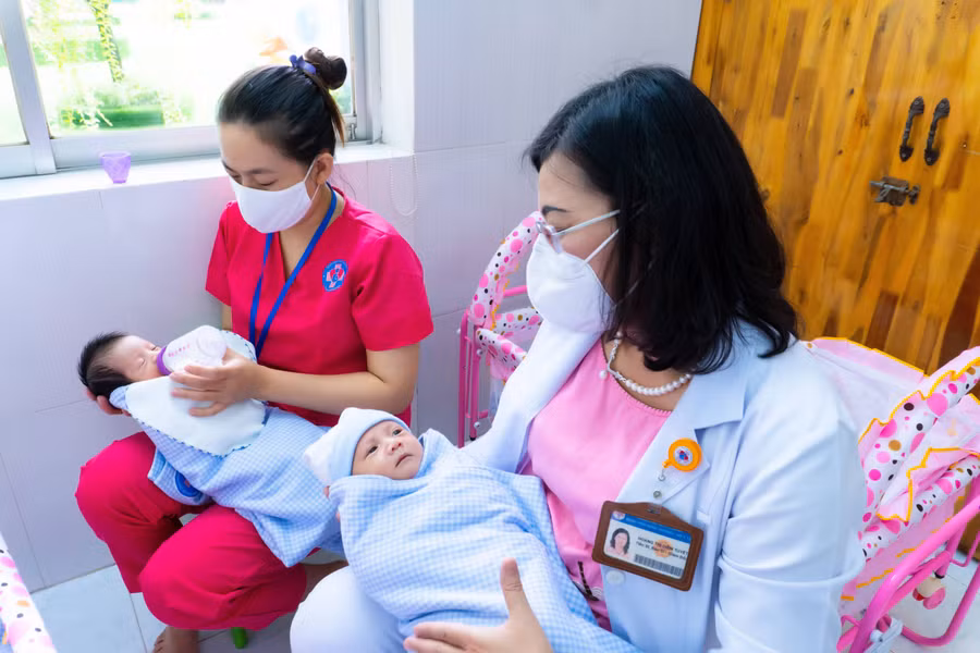 Bảo mẫu và bác sĩ Bệnh viện Hùng Vương cùng chăm sóc trẻ sơ sinh có mẹ mắc Covid-19 chờ người thân đón về. Ảnh chụp tháng 8/2021.