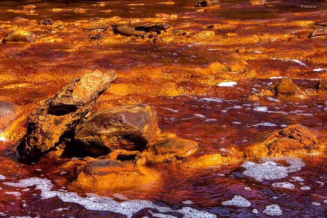 Sông Rio Tinto, Tây Ban Nha: Dòng sông chảy từ dãy núi Sierra Morena ở Andalusia có màu đỏ đặc biệt, do nồng độ axit trong nước sông rất cao, độ PH từ 1,7-2,5. Nước sông còn chứa nhiều kim loại nặng như vàng, bạc, đồng. Là nơi xả chất thải trong 5.000 năm khai mỏ, dòng sông hiện nay bị ô nhiễm trầm trọng. Sông Rio Tinto, Tây Ban Nha: Dòng sông chảy từ dãy núi Sierra Morena ở Andalusia có màu đỏ đặc biệt do nồng độ axit trong nước sông rất cao, độ PH từ 1.7 – 2.5. Nước sông còn giàu các loại kim loại nặng như vàng, bạc, đồng. Là nạn nhân của 5.000 năm khai mỏ, dòng sông hiện nay bị ô nhiễm trầm trọng.
