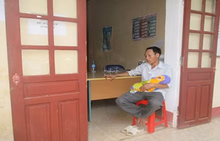 Người thân bế xác bé trai ngồi trước cửa phòng ở Trạm Y tế xã Xuân Thắng đòi làm rõ trách nhiệm. Ảnh: Hợp Thành/ VnExpress