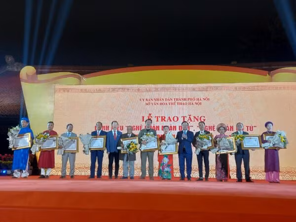Phó Chủ tịch UBND TP Hà Nội Chử Xuân Dũng và PGS.TS Bùi Hoài Sơn - Ủy viên Thường trực Ủy ban Văn hóa, Giáo dục của Quốc hội trao tặng danh hiệu Nghệ nhân Nhân dân cho các nghệ nhân. Ảnh: Sở VHTT Hà Nội.