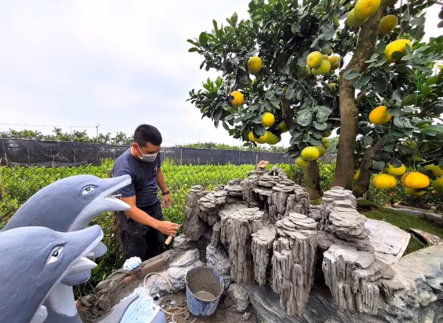 Một thợ tạo cảnh đang hoàn thiện dần tác phẩm 'Đất liền và biển cả'. Để hoàn thành chậu to nhiều chi tiết thợ đắp mất khoảng hai tháng rưỡi, chậu nhỏ hơn nửa tháng.